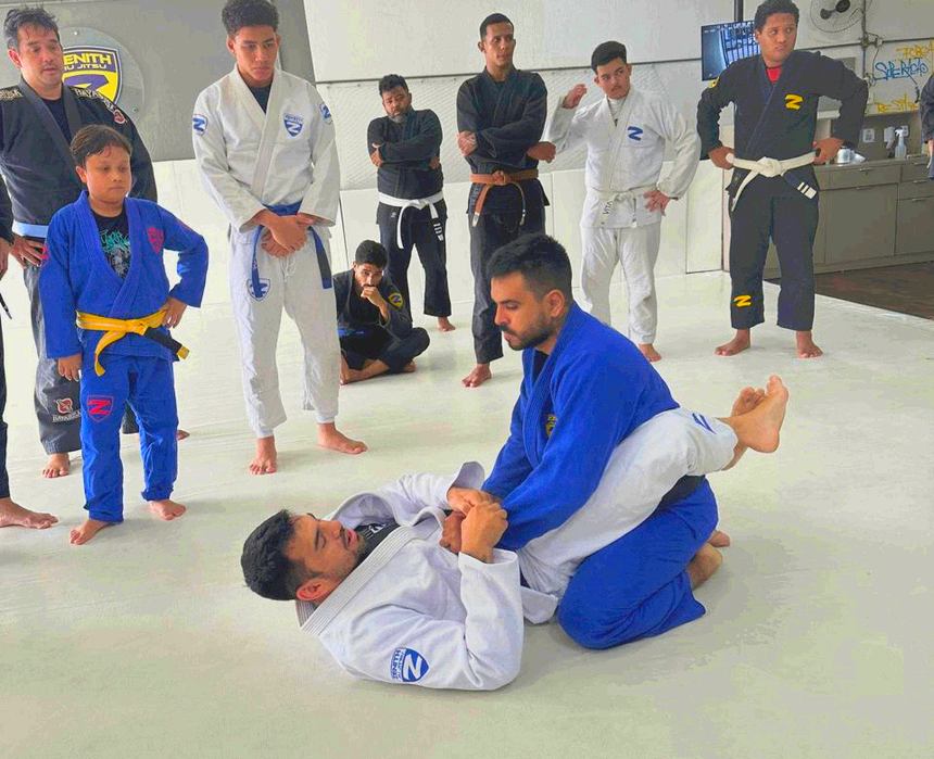 Professor da Zenith demonstrando uma técnica de chão com a turma em volta